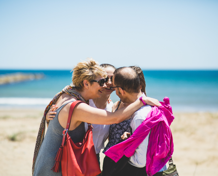 Espanjalainen isäntäperhe halaamassa omaa vahto-oppilasta rannalla
