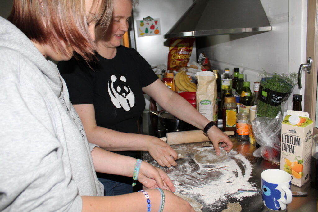 Vaihto-oppilas leipoo isäntäperheen äidin kanssa karjalanpiirakoita